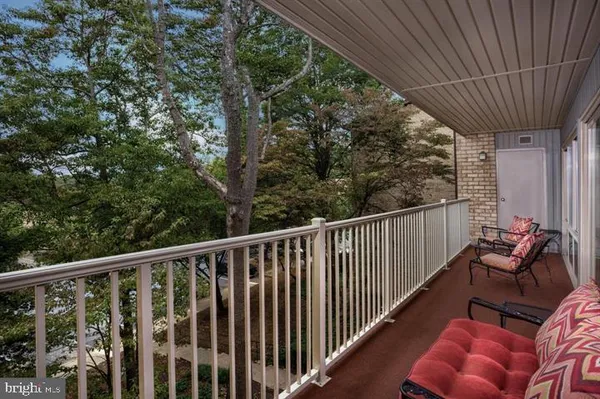 a balcony with wooden floor stairs and furniture