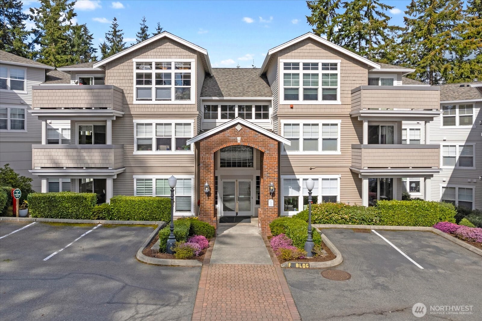 8500 Main Street, Unit F205 Edmonds, WA 98026 - Photo 2 of 30 a front view of a house with a garden