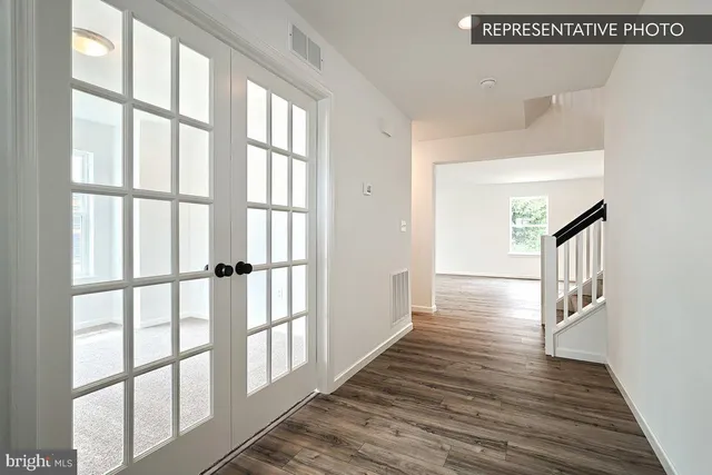 a view of a hallway with wooden floor and staircase