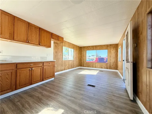 a kitchen with granite countertop wooden cabinets and a wooden floor