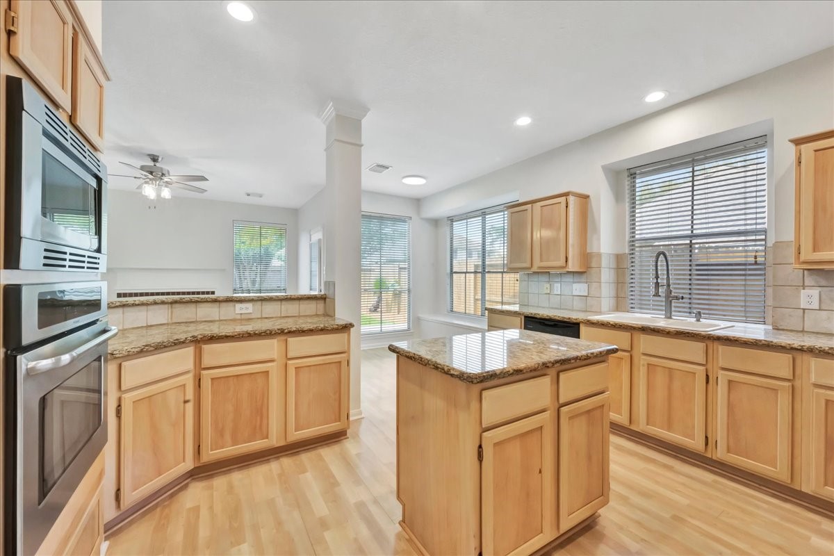 14010 Hazel Ridge Court Houston, TX 77062 - Photo 14 of 38 The breakfast bar is located next to the ovens with easy access to the family room (where the ceiling fan is).