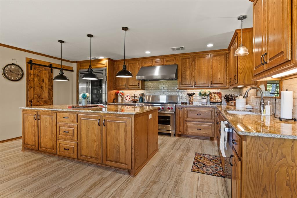 78 County Road 2137 Pittsburg, TX 75686 - Photo 12 of 40 a kitchen with stainless steel appliances granite countertop a sink a stove and a wooden floors