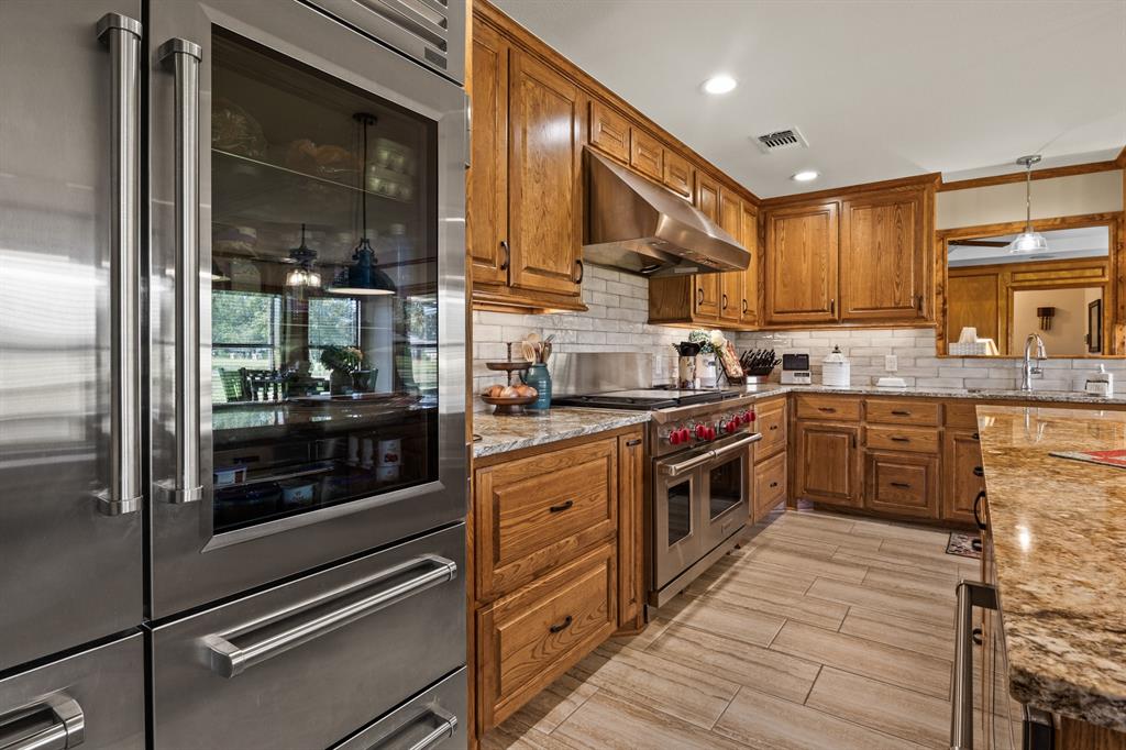 78 County Road 2137 Pittsburg, TX 75686 - Photo 15 of 40 a kitchen with stainless steel appliances granite countertop a stove a sink and a refrigerator