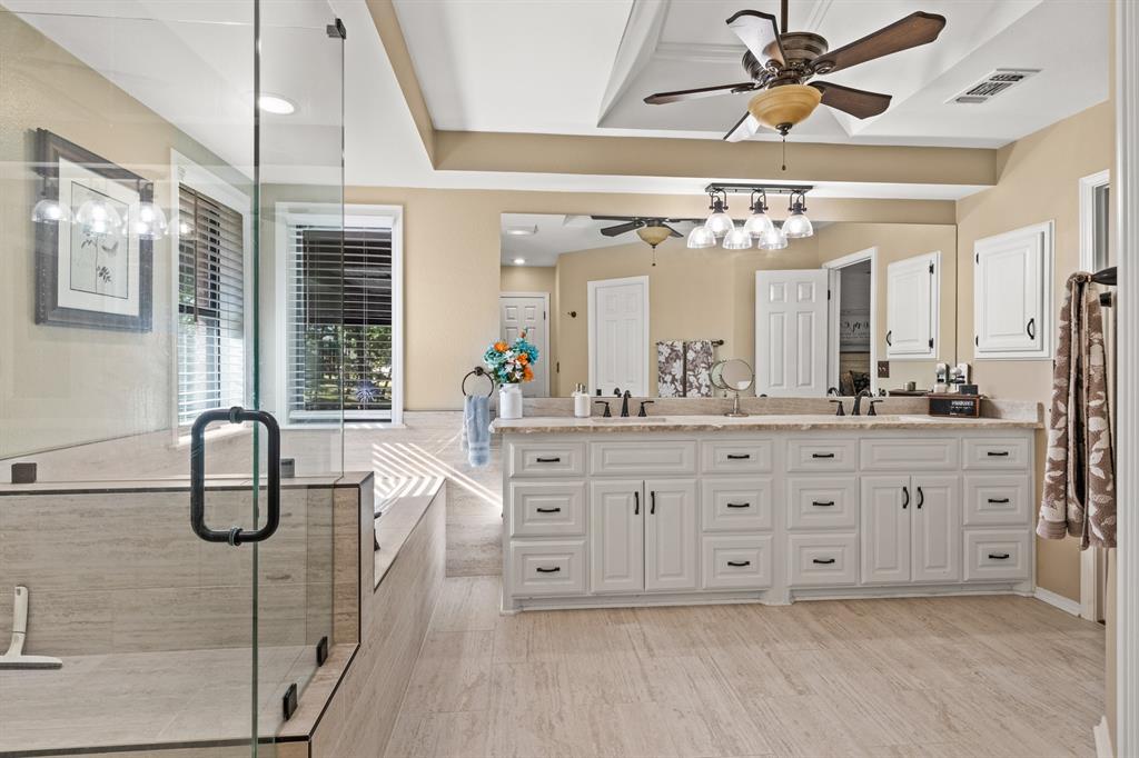 78 County Road 2137 Pittsburg, TX 75686 - Photo 25 of 40 a spacious bathroom with a double vanity sink a mirror and a shower