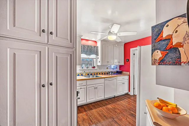 a kitchen with stainless steel appliances granite countertop a stove a sink and a refrigerator with wooden floor