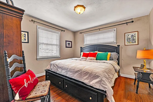 a bedroom with a bed and a dresser next to a window