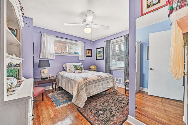 a bedroom with a bed rug and wooden floor