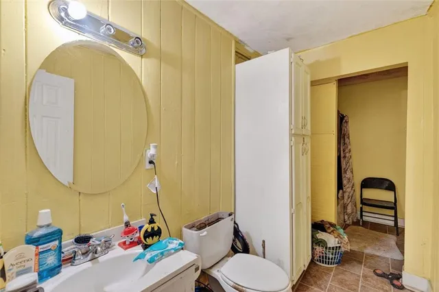 a bathroom with a toilet sink and mirror