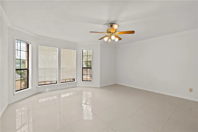an empty room with windows and chandelier