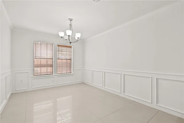 an empty room with chandelier fan