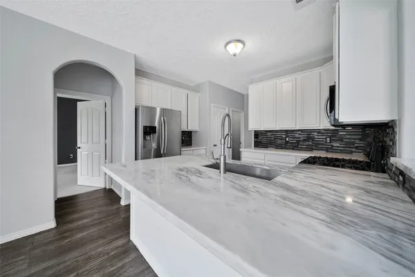 a kitchen with stainless steel appliances granite countertop a sink stove and cabinets