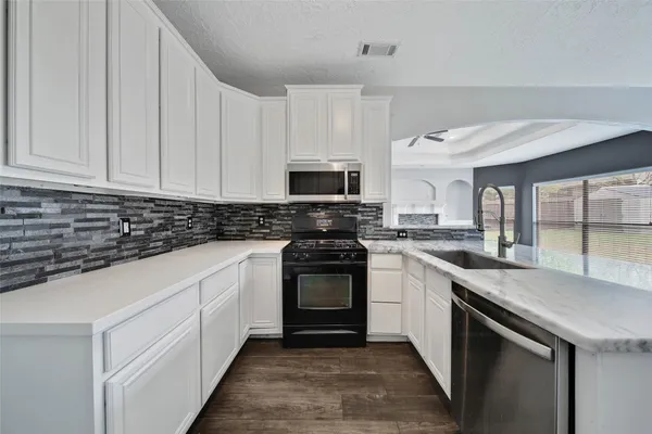 a kitchen with granite countertop a sink and a stove top oven