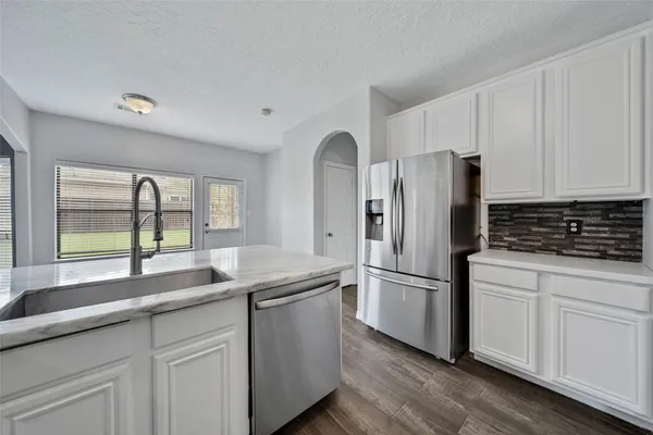 a kitchen with stainless steel appliances granite countertop a refrigerator and a sink