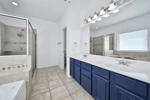 a spacious bathroom with a double vanity sink mirror and shower