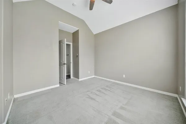 an empty room with closet and a chandelier fan
