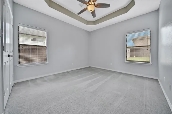 an empty room with a window and a fan
