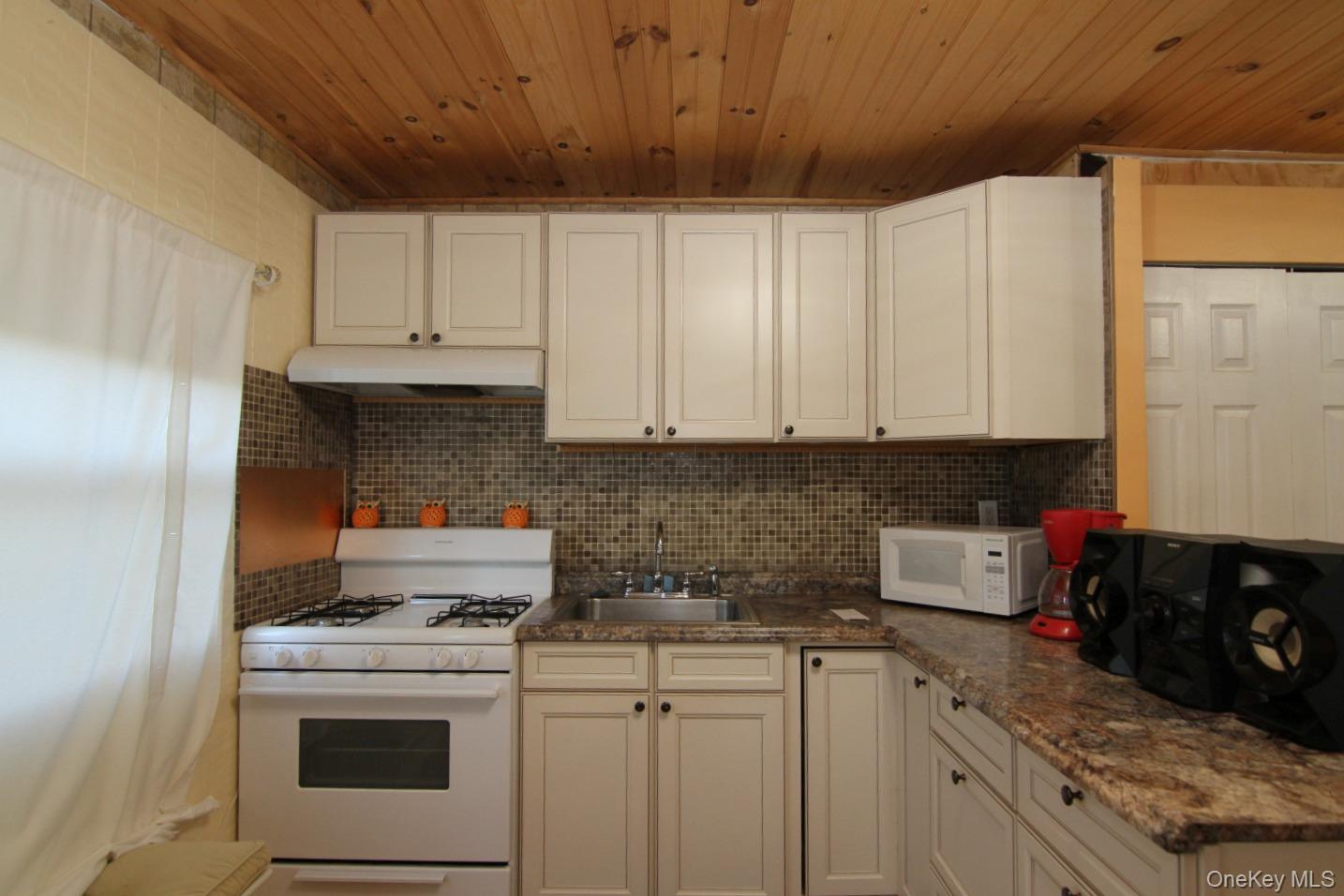191 Sylvan Lake Road, Unit 16 Hopewell Junction, NY 12533 - Photo 19 of 34 a kitchen with stainless steel appliances granite countertop a stove a refrigerator a sink dishwasher and white cabinets