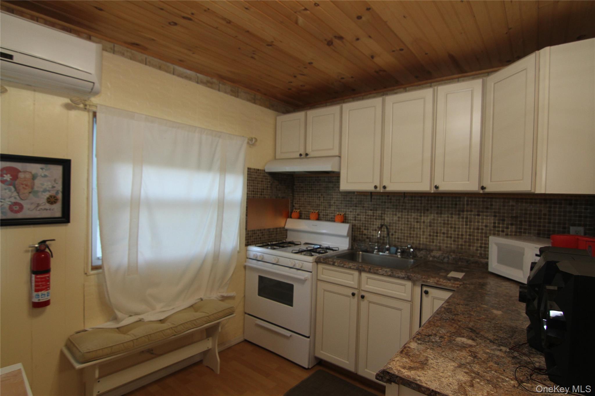191 Sylvan Lake Road, Unit 16 Hopewell Junction, NY 12533 - Photo 20 of 34 a kitchen with granite countertop a refrigerator a stove and white cabinets