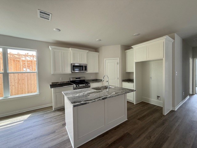 2602 Falcon Ridge Drive Bryan, TX 77803 - Photo 6 of 15 a kitchen with stainless steel appliances granite countertop a stove a refrigerator a sink a microwave and wooden floor