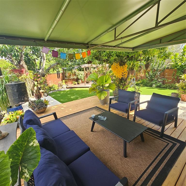 a living room with patio furniture and a floor to ceiling window