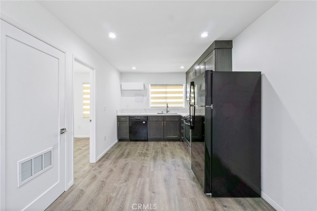 6212 Santa Rita Avenue Garden Grove, CA 92845 - Photo 38 of 50 a kitchen with stainless steel appliances a refrigerator and a wooden floor