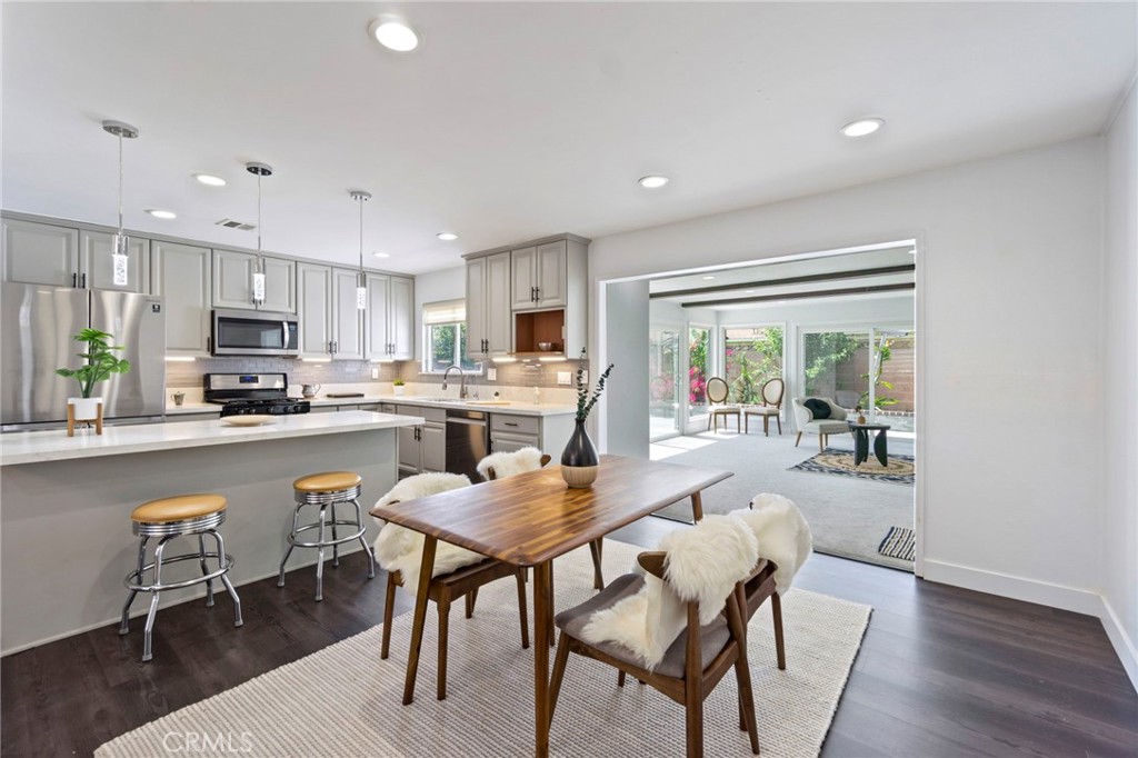6212 Santa Rita Avenue Garden Grove, CA 92845 - Photo 10 of 50 a dining room with stainless steel appliances granite countertop a stove a refrigerator a sink a stove and white cabinets with wooden floor