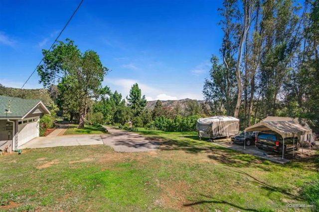 a view of a backyard with table and chairs under an umbrella