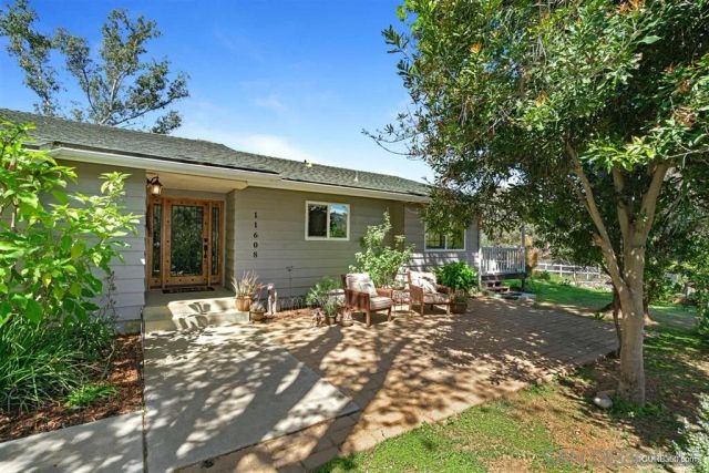 a view of a house with backyard sitting area and garden