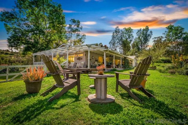 a view of a swimming pool with sitting area and garden