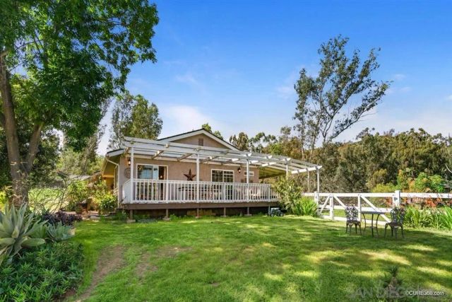 a view of a house with a yard deck and a garden