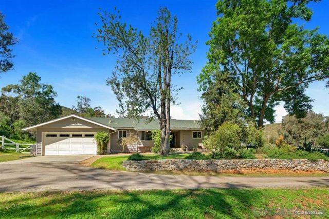 a view of a house with a yard and tree s