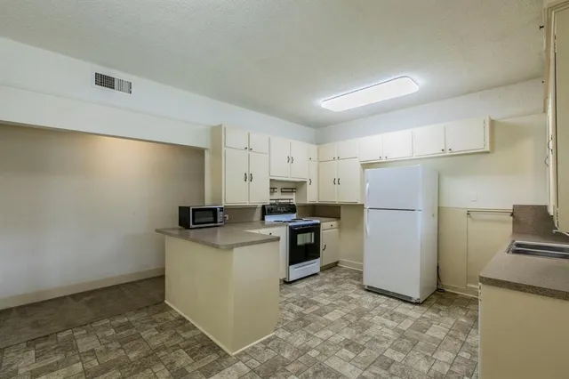 a kitchen with a refrigerator sink stove and cabinets