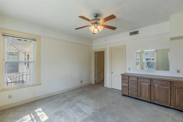 a view of an empty room with window and cabinet