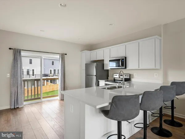 a kitchen with granite countertop a refrigerator and a stove top oven