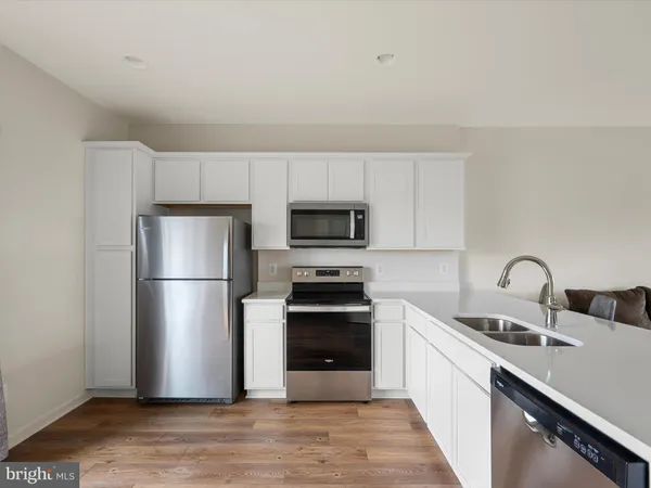a kitchen with a sink a refrigerator and a stove top oven