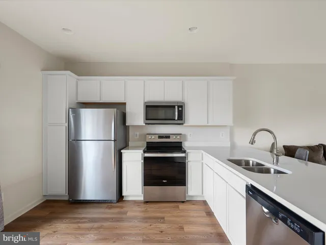 a kitchen with a sink a refrigerator and a stove top oven