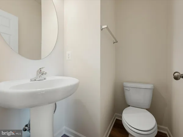a bathroom with a toilet a sink and mirror