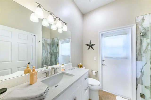 a spacious bedroom with a large bed a chandelier and windows