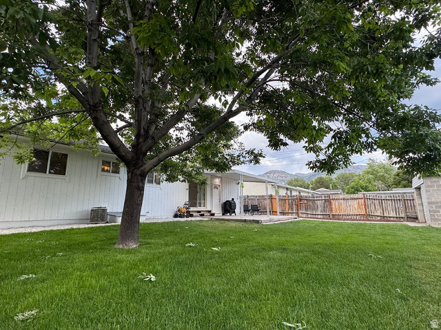 1791 West 170 South, Unit 8 Provo, UT 84601 - Photo 21 of 25 Expansive green lawn featuring a mature tree, white siding exterior, and a rear patio