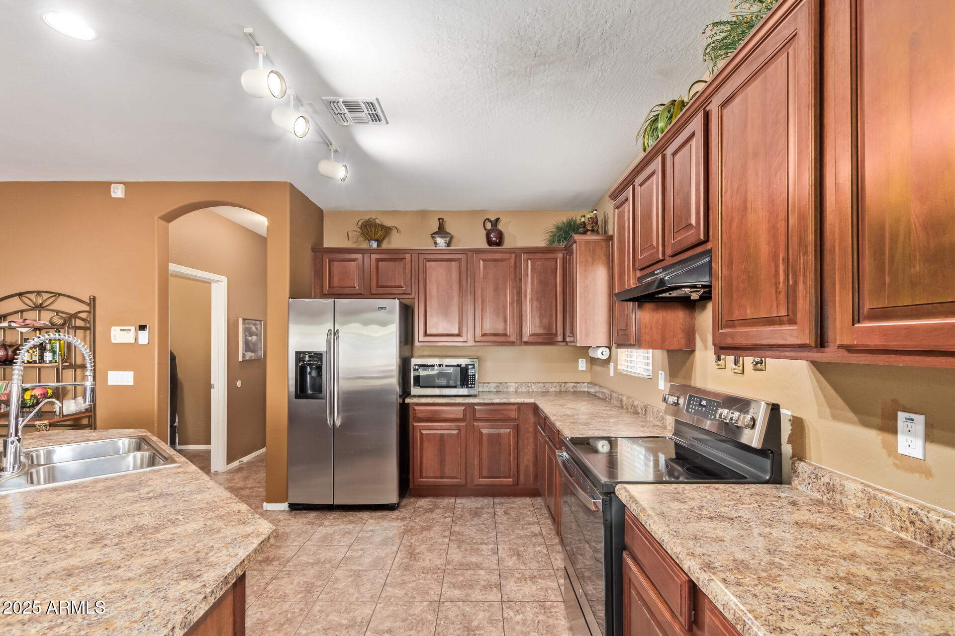 6934 West Beverly Road Laveen, AZ 85339 - Photo 10 of 31 a kitchen with stainless steel appliances granite countertop a refrigerator a sink and a stove