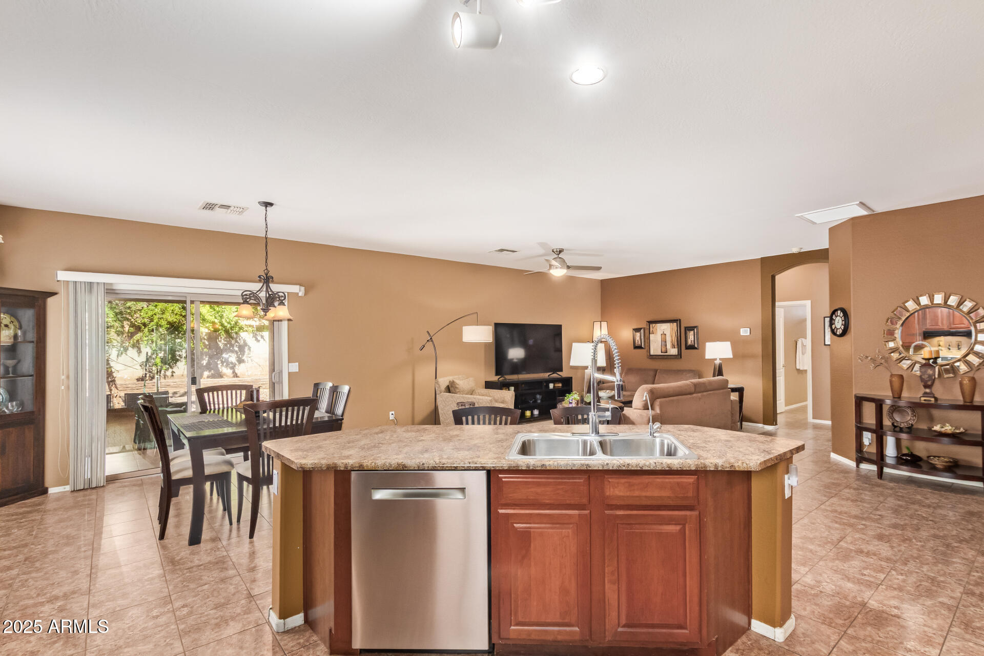 6934 West Beverly Road Laveen, AZ 85339 - Photo 12 of 31 a kitchen with kitchen island granite countertop a table chairs stove a sink and dishwasher a refrigerator with wooden floor