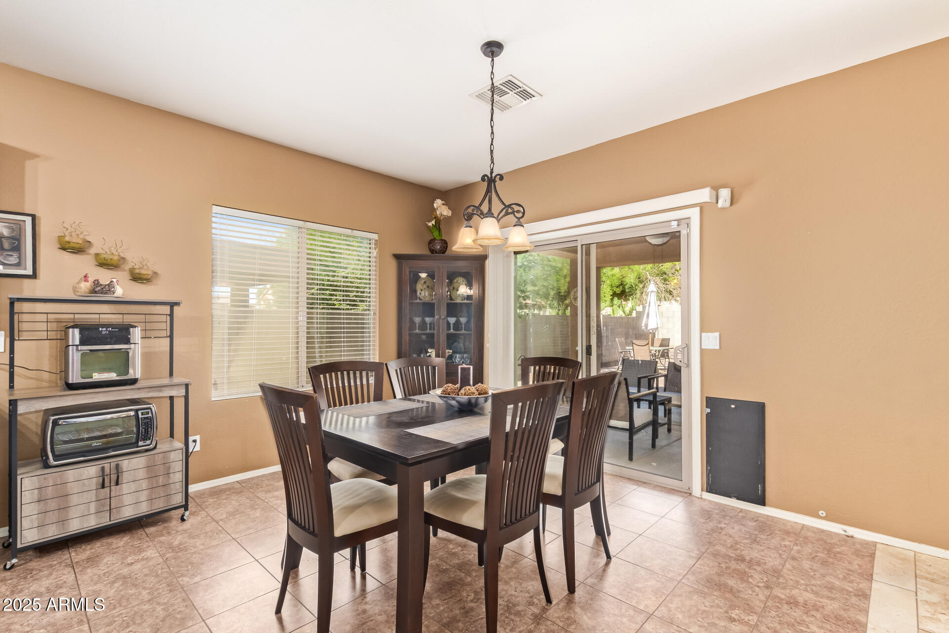 6934 West Beverly Road Laveen, AZ 85339 - Photo 8 of 31 a dining room with furniture a chandelier and window