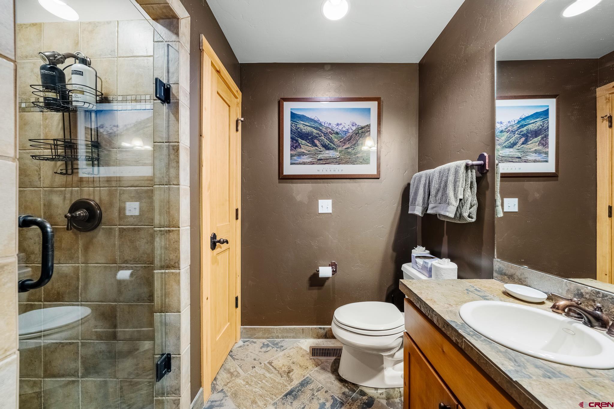 114 Limestone Court Durango, CO 81301 - Photo 4 of 35 a bathroom with a granite countertop toilet a sink and shower