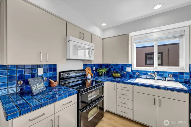 a kitchen with granite countertop a sink stainless steel appliances and cabinets