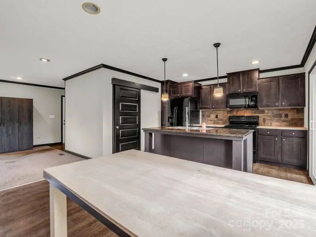 a kitchen with stainless steel appliances kitchen island a refrigerator sink and cabinets