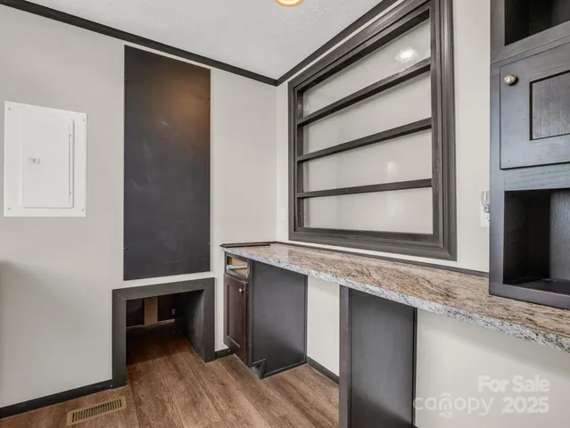 a kitchen with white cabinets and a wooden floor