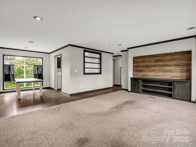 a view of empty room with a fireplace and window