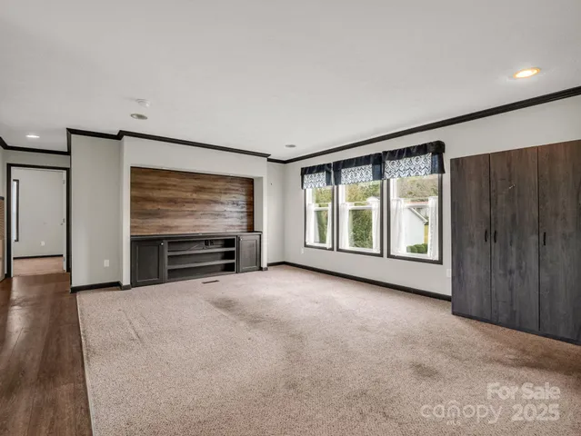 a view of an empty room with furniture and window