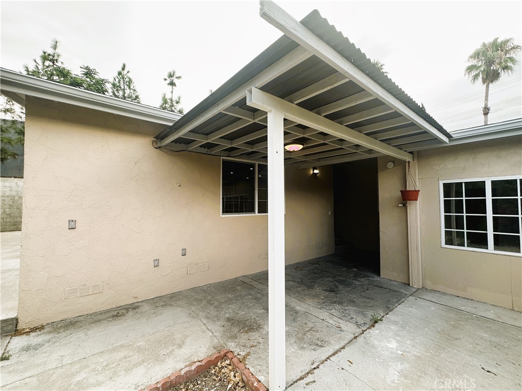 a view of a house with a wooden bench in patio