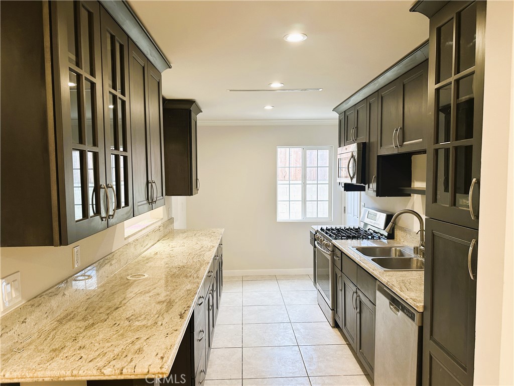 7307 Foothill Boulevard Tujunga, CA 91042 - Photo 8 of 27 a kitchen with stainless steel appliances kitchen island granite countertop a sink stove and cabinets